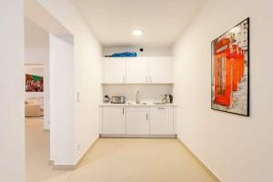 een keuken met witte kasten en een schilderij aan de muur bij Berlin Mitte I 2 doule beds I fast wifi in Berlijn +17 foto's