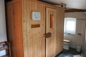 a wooden bathroom with a toilet and a window at Ferienwohnung Buchholz in Warnitz