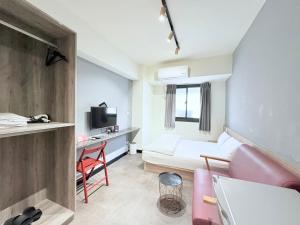 a living room with a couch and a desk in a room at 逢甲 築光 in Taichung
