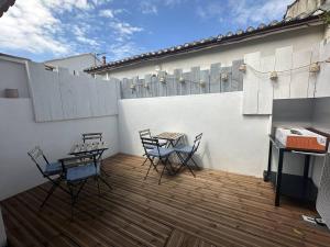 a patio with chairs and a table and a fence at Superbe RDC terrasse centre ville clim wifi in Saintes-Maries-de-la-Mer