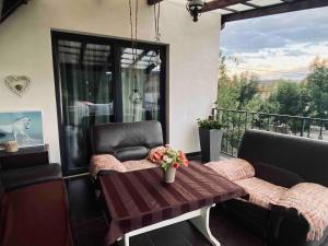 a patio with a table and chairs and a balcony at Mini Vacanta La Munte in Zărneşti