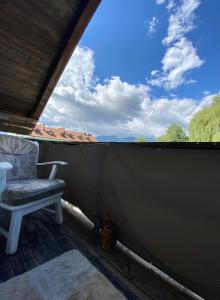 a chair sitting on a screened in porch with a view at Mini Vacanta La Munte in Zărneşti