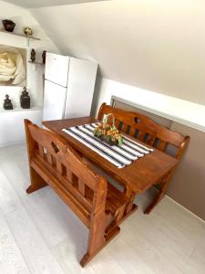 a wooden bench with a table and a refrigerator at Mini Vacanta La Munte in Zărneşti +8 photos