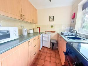een keuken met een spoelbak en een magnetron bij Dog Friendly Chalet At Broadland Park And Marina In Lowestoft Ref 12027B in Lowestoft +9 foto's
