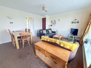 een woonkamer met een bank en een tafel bij Dog Friendly Chalet At Broadland Park And Marina In Lowestoft Ref 12027B in Lowestoft