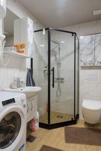 a bathroom with a shower and a washing machine at Apartman Dolly Vrnjacka banja in Vrnjačka Banja