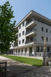 a white building with balconies on the side of it at Apartman Dolly Vrnjacka banja in Vrnjačka Banja