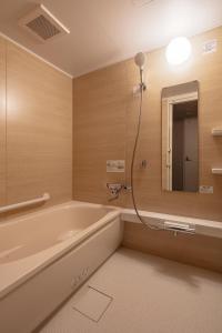 a bathroom with a bath tub and a mirror at GINNOYADO Main Location in Kyoto