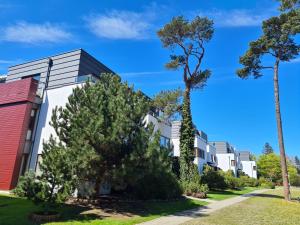 a row of apartment buildings with trees at Apartament Mestwina 54 Jurata in Jurata +5 photos