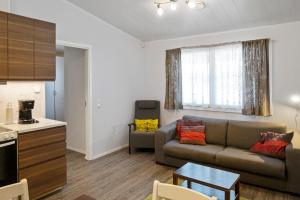 a living room with a couch and a table at Ekokatti Cottages in Vuokatti