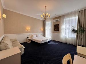 a hotel room with a bed and a couch at Odeska Astoria in Odesa