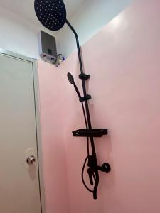 un pied de microphone dans une pièce avec un mur rose dans l'établissement HANA extension rooms, à El Nido