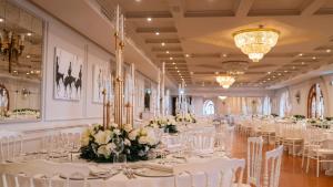 a banquet hall with white tables and white chairs at Altafiumara Resort & Spa in Villa San Giovanni +285 photos