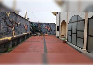 a brick walkway with a mural on the side of a building at NEFAR PALACE HOTEL Plc in Bafoussam