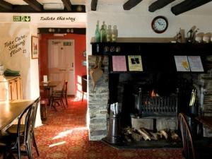 a restaurant with a fireplace and a table and chairs at Lifton Hall in Lifton +14 photos