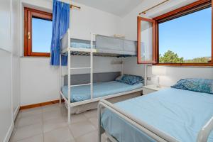 a bedroom with two bunk beds and a window at Casa Sardina in Costa Dorata