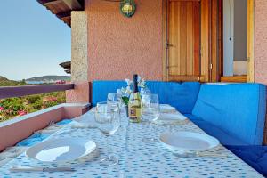 a table with plates and wine glasses on it at Casa Sardina in Costa Dorata