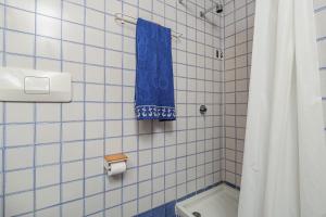 a blue and white tiled bathroom with a blue towel at Casa Sardina in Costa Dorata