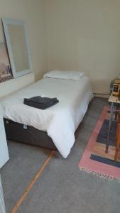 une chambre avec un lit sur lequel se trouve une robe de chambre noire dans l'établissement Townsend Studio/Rooms, à Liverpool 3 autres photos