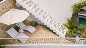 an overhead view of a staircase with an umbrella and chairs at Pagi Villas by Betterplace in Canggu