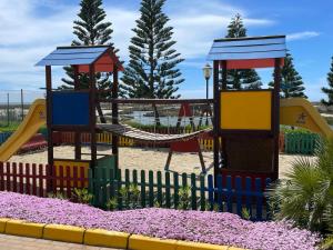 een speeltuin met een glijbaan en schommels bij Villa Romana Roquetas in Roquetas de Mar