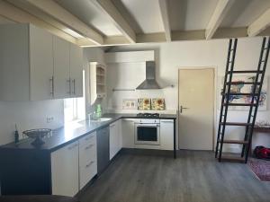 a kitchen with white cabinets and a ladder in it at Zonneoord in Ede +5 photos