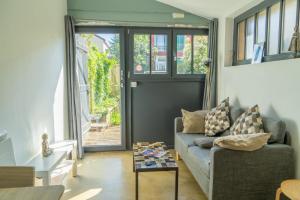 a living room with a couch and a table at Studio 22m2 proche Paris station Aerobus Beauvais in Pierrefitte-sur-Seine
