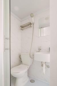 a white bathroom with a toilet and a sink at Kailani in Kalyves