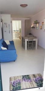 een woonkamer met een blauwe bank en een tafel bij Melograno2 in Torre San Giovanni Ugento
