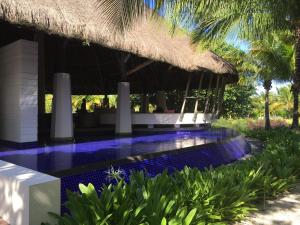 a resort with a swimming pool and a resort with palm trees at Villa Serenité in Bel Ombre
