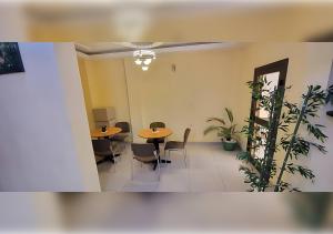 a meeting room with two tables and chairs and plants at NEFAR PALACE HOTEL Plc in Bafoussam +29 photos