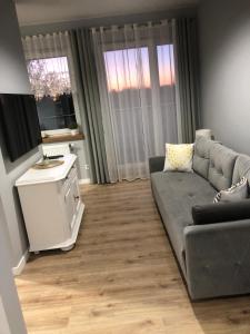 a living room with a couch and a tv at Apartament diamentowy in Konin +2 photos