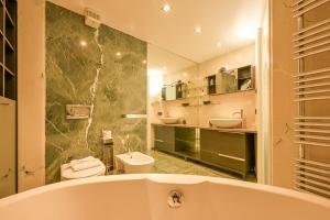 a bathroom with a tub and two sinks and a toilet at The Star Loft - A Luxury top floor in Como +24 photos