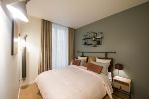 a bedroom with a bed and a chandelier at Magnifique appartement central 3 chambres / 3 BDR in Paris