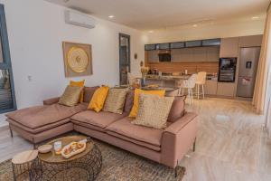 a living room with a couch and a kitchen at La villa Socé in Saly Portudal