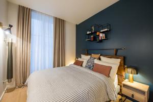 a bedroom with a large bed and a blue wall at Magnifique appartement central 3 chambres / 3 BDR in Paris +12 photos