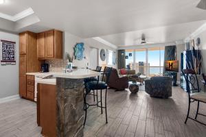a kitchen and living room with a counter and chairs at St. Lucia 1103 in Destin