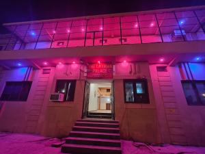 a building with pink and purple lights on it at Hotel Laxmanam Residency - 900 meters from Shree Ram Temple Ayodhya in Ayodhya