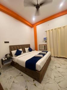 a bedroom with a large bed with blue pillows at Hotel Laxmanam Residency - 900 meters from Shree Ram Temple Ayodhya in Ayodhya