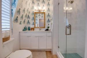 een badkamer met een toilet, een wastafel en een spiegel bij Custom House Inn All in Key West +73 foto's