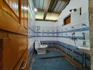 a bathroom with a toilet and a sink at Yalakhom, Stay & Cafe in Kulu