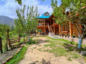 a log house with a blue roof and a fence at Yalakhom, Stay & Cafe in Kulu