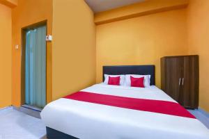 a bedroom with a large white bed with red pillows at Coop Hotel Kangar in Kangar +42 photos
