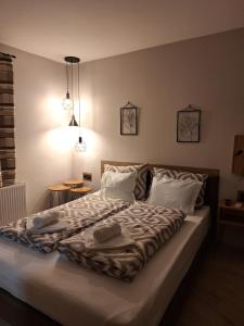 a bedroom with a large bed with white sheets and pillows at Guest House Dimitrije in Niška Banja