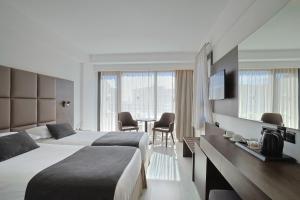 a hotel room with two beds and a table at Odysseia Hotel Kapetanios in Limassol