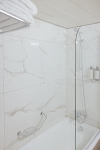 a shower with a glass enclosure in a bathroom at Odysseia Hotel Kapetanios in Limassol
