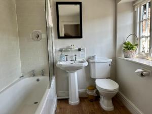 a white bathroom with a toilet and a sink at The Talbot in Shillingstone
