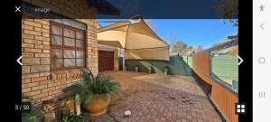 een afbeelding van een bakstenen huis met een paraplu bij Kamga House in Bloemfontein