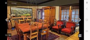 een eetkamer met een houten tafel en stoelen bij Kamga House in Bloemfontein