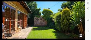 een huis met een tuin met gras en bomen bij Kamga House in Bloemfontein +4 foto's